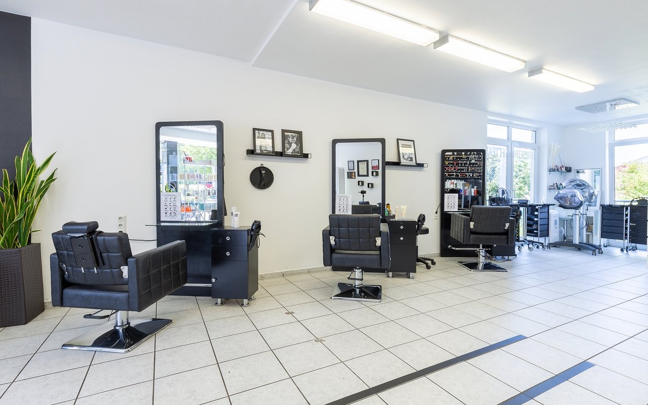 Heller Salon Friseur H Team mit schwarzen Friseurstühlen und großen Spiegeln